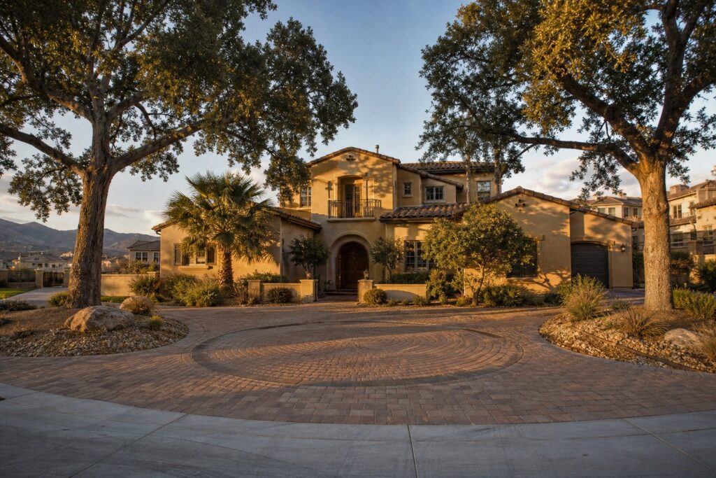 Two-story Valencia home with mature trees, circular driveway, and desert landscaping in Santa Clarita master-planned community.