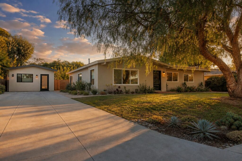 Northridge home with detached garage conversion ADU and mature pepper tree in late afternoon sunlight.