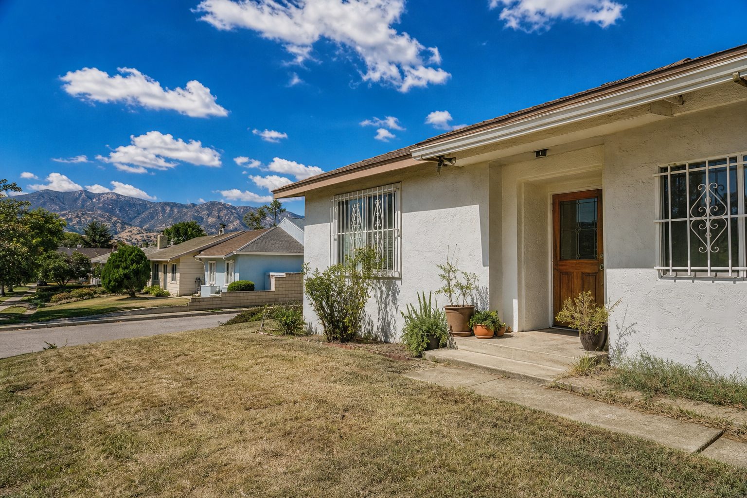 Updated 1970s ranch home with contemporary entry, mature front yard, and neighborhood street view in Northridge.