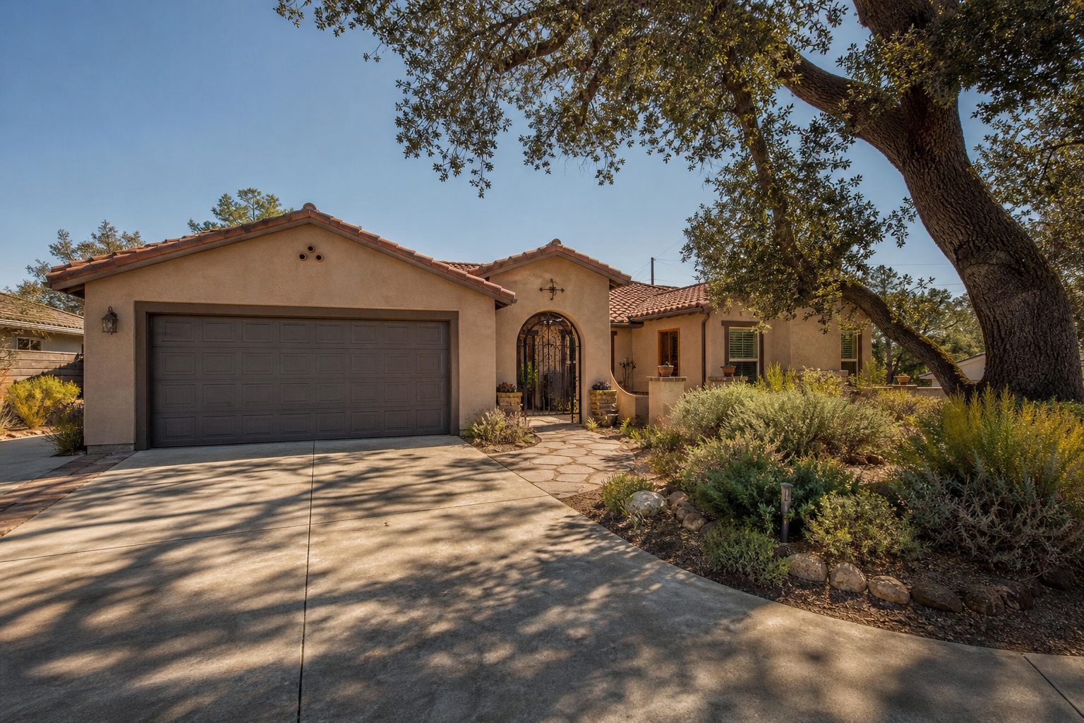 Single-story Canyon Country home with tan stucco, tile roof, native drought-resistant landscaping, and clear Santa Clarita valley sky.