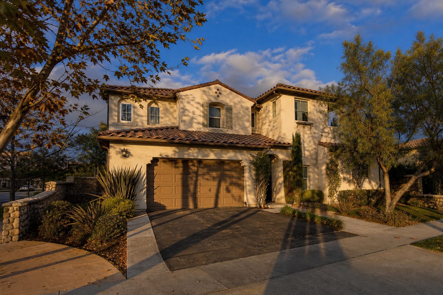 Two-story Valencia home with stucco facade and mature landscaping in golden hour light, typical West Creek neighborhood architecture.