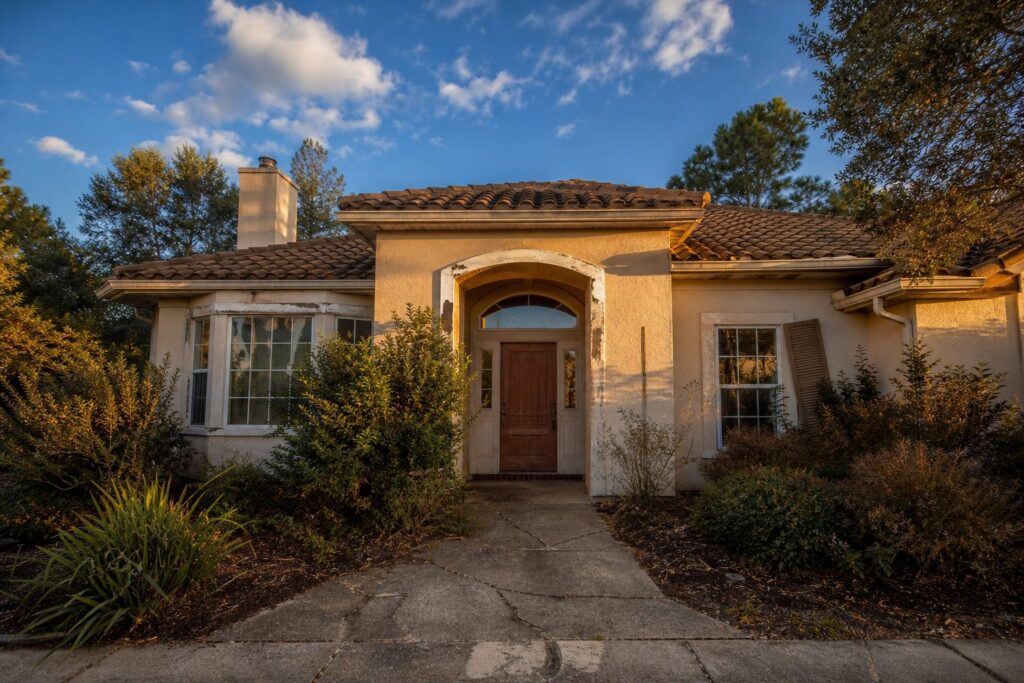 Single-story Valencia home with peeling trim, neglected landscaping, and cracked driveway showing visible deferred maintenance.
